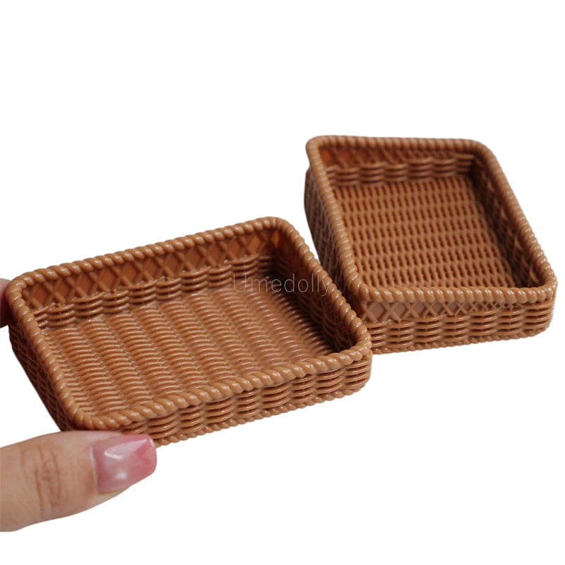 A small, rectangular woven basket made of brown wicker, shown being held by a hand.