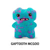 A teal plush monster with purple spots and a wide grin.