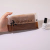 A hand holds a package of OUMMAA wood clay and a black cosmetic tube.