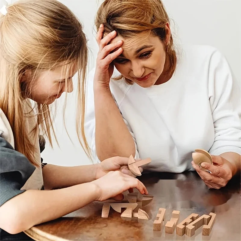 Two people are assembling a wooden brain teaser puzzle game on a table.