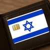 A close-up of a credit card skin sticker featuring the flag of Israel on a dark leather wallet.