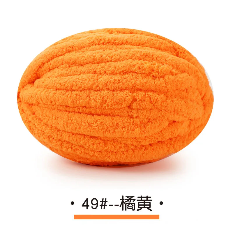 A ball of bright orange chunky chenille yarn for hand knitting projects.