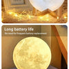 A glowing moon-shaped night light featuring a cartoon duck design, used as a decorative item.
