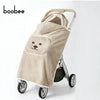 A beige baby windproof cape blanket with a dinosaur design is shown on a stroller.