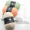 Three skeins of soft milk cotton yarn in light green, peach, and cream colors with labels indicating grade and weight.