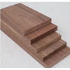 A stack of handcrafted black walnut wood boards with varying thicknesses, showing the grain and finish.