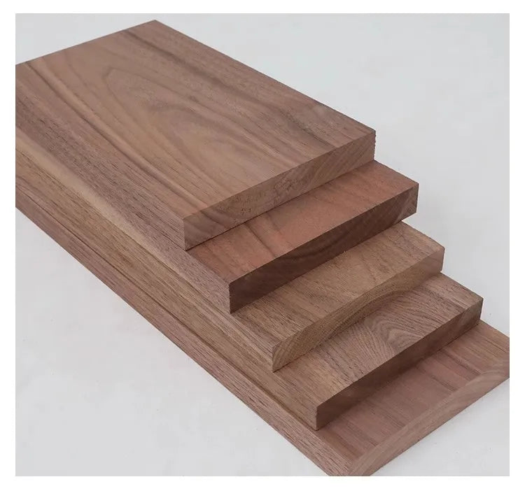 A stack of handcrafted black walnut wood boards with varying thicknesses, showing the grain and finish.