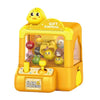 A yellow mini claw machine toy for kids featuring a clear display and several small yellow and brown plush toys.