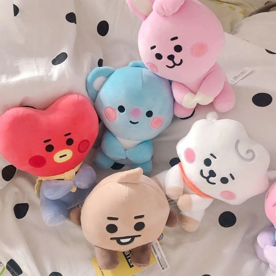 A collection of pink and blue kawaii anime mini plush keychains resting on a white polka-dot surface.