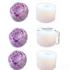 A set of silicone molds shaped like flowers and pillar candles in light purple and white.