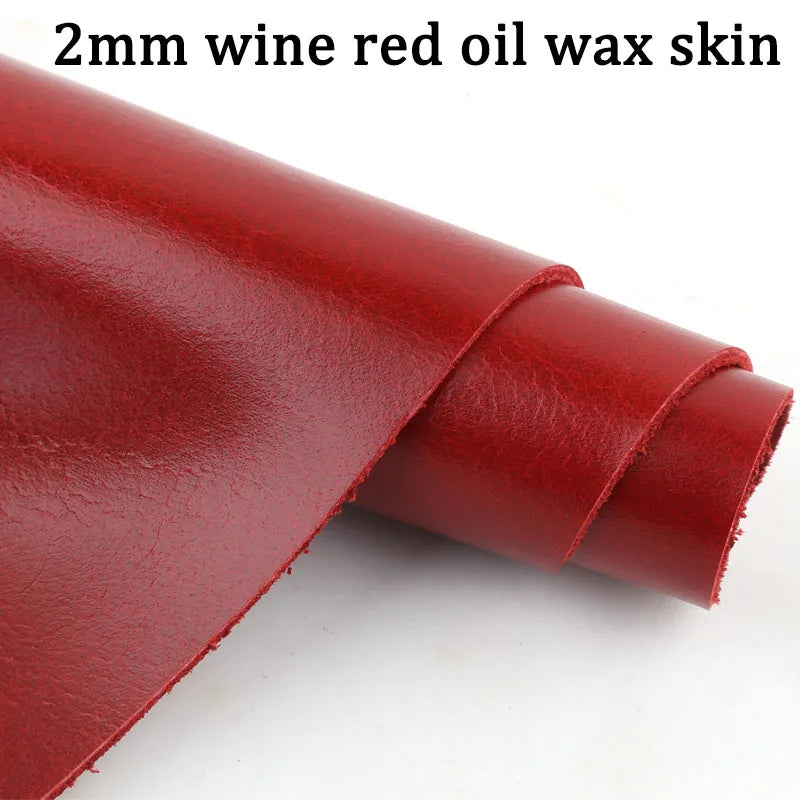 A close-up view of a 2mm wine red oil wax skin leather sheet rolled up.