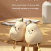 Two adorable pear-shaped night lights sitting on a wooden table with soft lighting.
