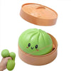 A light green squishy toy shaped like a cactus is shown in its open box with a lid.