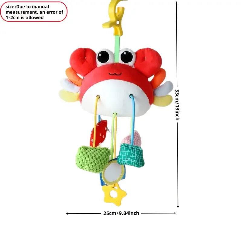A yellow crab-themed baby rattle and teether toy with a hanging strap, featuring red claws and a white body.