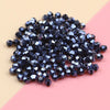A pile of dark blue iridescent crystal glass beads for jewelry making