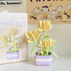 A miniature flower bouquet building block set featuring yellow and green flowers in a purple box.