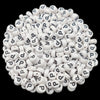 A pile of small white acrylic alphabet letter beads for jewelry making