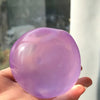 A smooth, translucent purple squishy stress relief toy held in a hand.