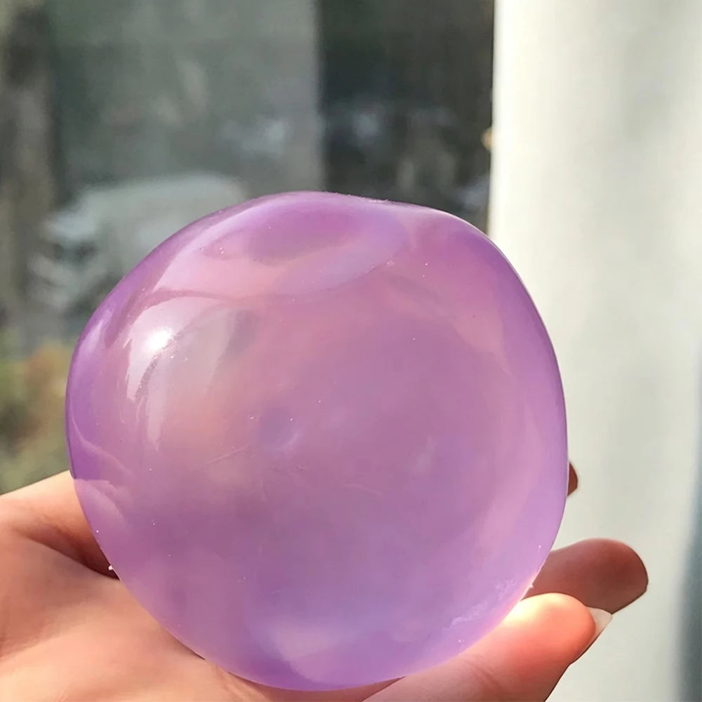 A smooth, translucent purple squishy stress relief toy held in a hand.