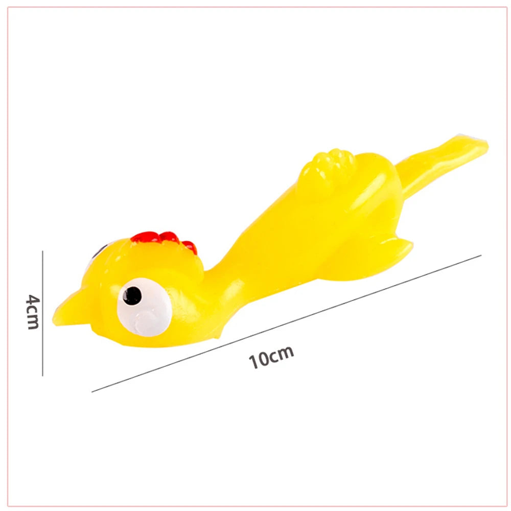 Yellow catapult chicken flying toy with a red comb and large eye, shown in profile.