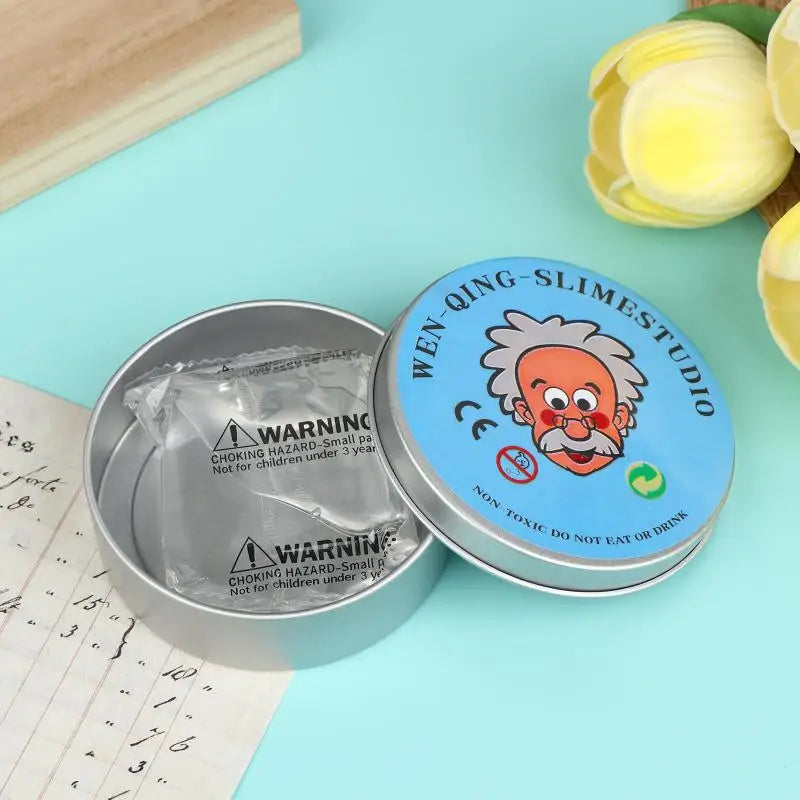 A tin of Wen-Qing Slime for stress relief next to a piece of paper and yellow flowers.