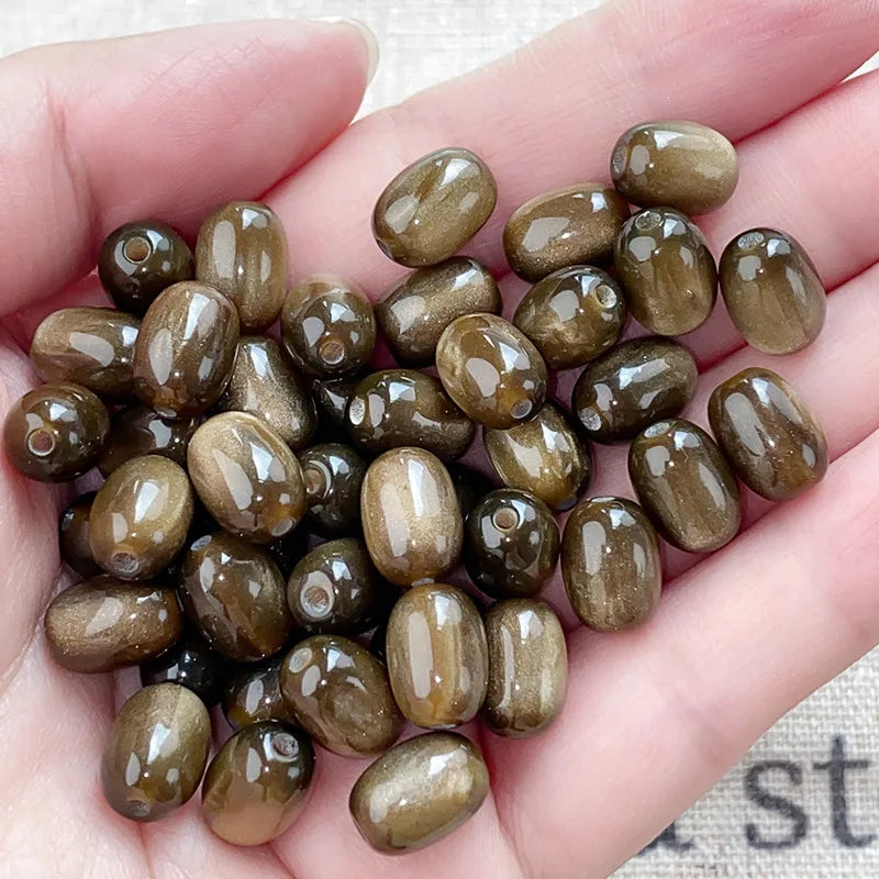 A handful of ten brown and gold resin starry sky cat's eye beads for jewelry making