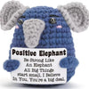 A handmade crochet elephant plush toy in blue and gray with an inspirational quote about believing in oneself.