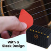 A hand places a red guitar pick holder onto a black storage box with a sleek design.