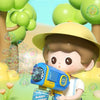 A young boy is playing with a yellow and blue electric bubble machine toy, surrounded by green bubbles.
