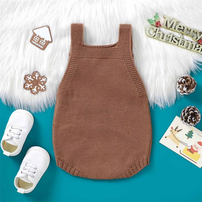 A brown knit baby Christmas romper with white embroidery and a gold-colored holiday design displayed on a teal background.