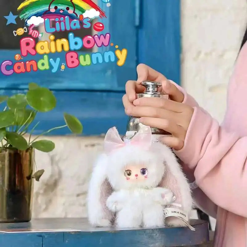 A fluffy white bunny toy from the Liila Rainbow Candy Bunny series is displayed on a blue surface.