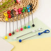 A collection of metal keychain bars with lobster clasps in various colors and finishes, laid on a light background.