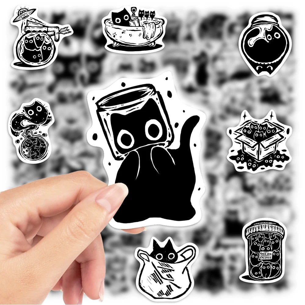 A hand holds a pack of fantasy black cat waterproof stickers on a dark background.