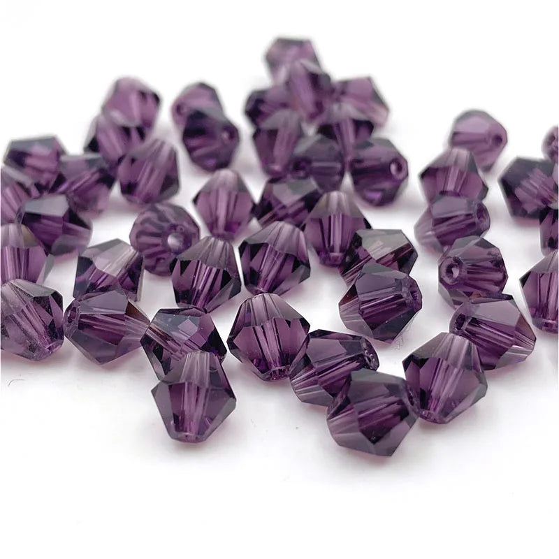 A collection of faceted purple bicone crystal glass beads for jewelry making.