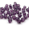 A collection of faceted purple bicone crystal glass beads for jewelry making.