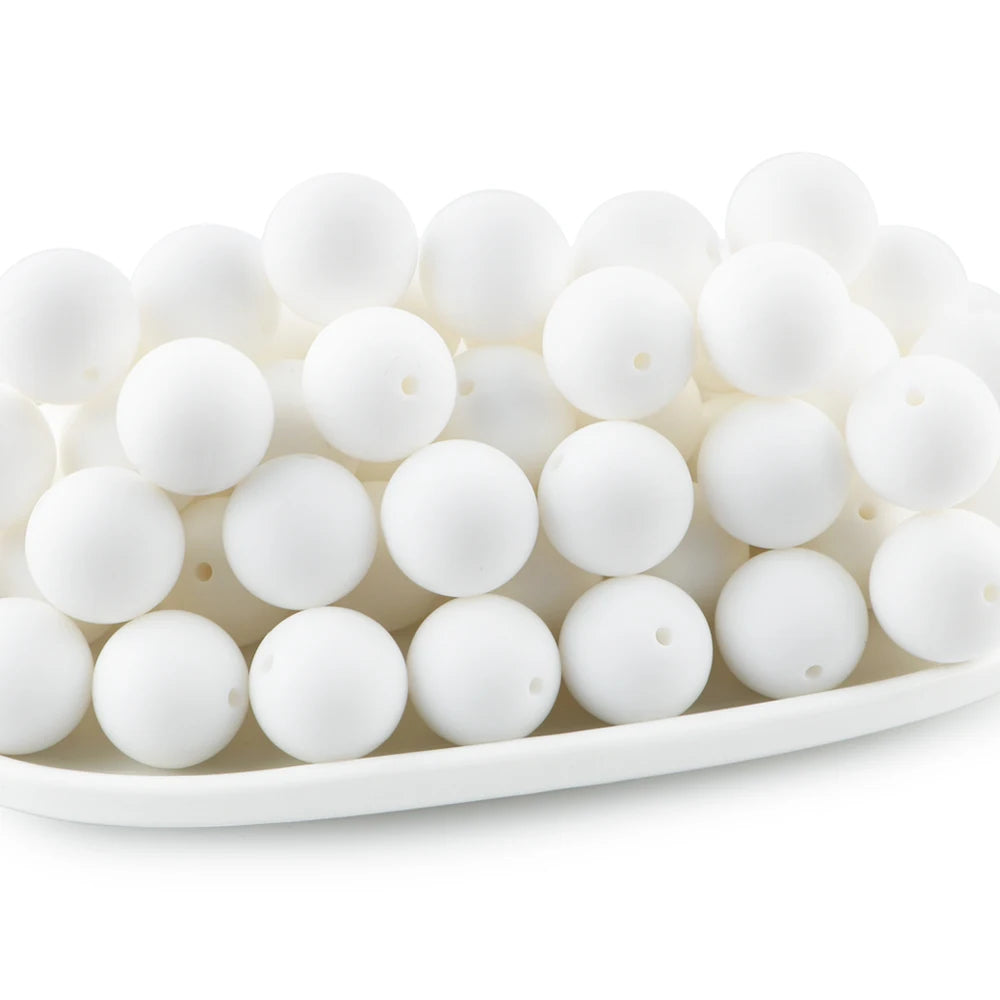 A white tray filled with small, round white silicone beads for jewelry making and DIY crafts.