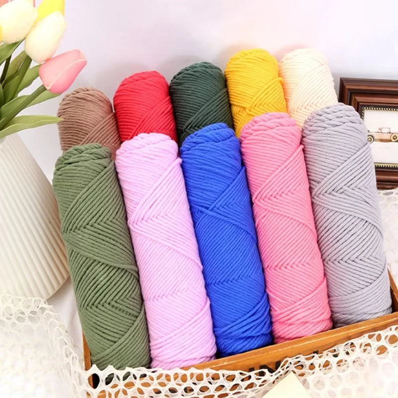 A collection of brightly colored premium milk cotton yarn spools in various shades like pink, blue, green, and yellow arrange