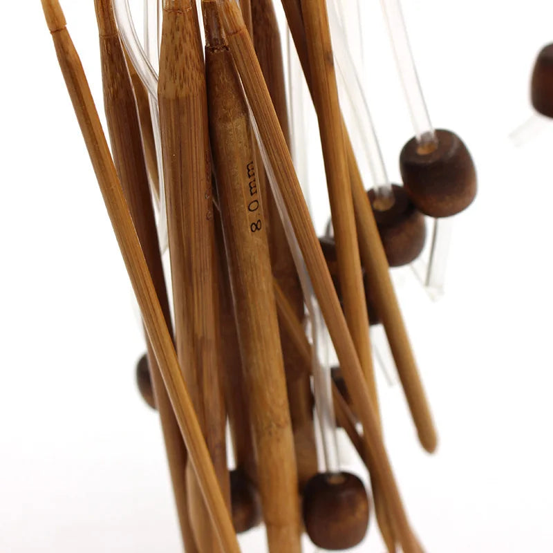 A close-up view of a set of flexible bamboo Tunisian crochet hooks with various sizes hanging together.