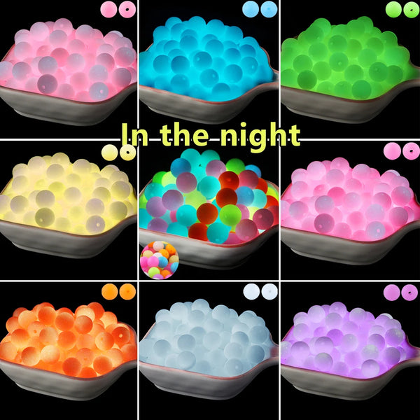 A collection of glow in the dark silicone beads in various colors and shapes displayed in a bowl.