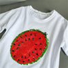 White long-sleeve t-shirt featuring a large red watermelon design covered in black seeds and green rind sequins