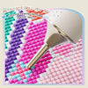 A silver metal dot drill pen tip is shown used for creating painting patterns and dot drills on a colorful surface.