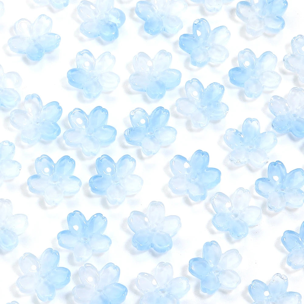 A close-up of a 50-piece set of light blue cherry blossom flower glass beads for jewelry making.