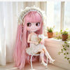 A pink hair fashion doll with white floral crown and dress sitting on a white stool near a window.