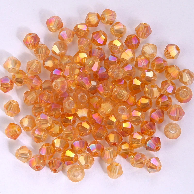 A pile of small, faceted, orange-colored glass beads shaped like bicones for jewelry making.