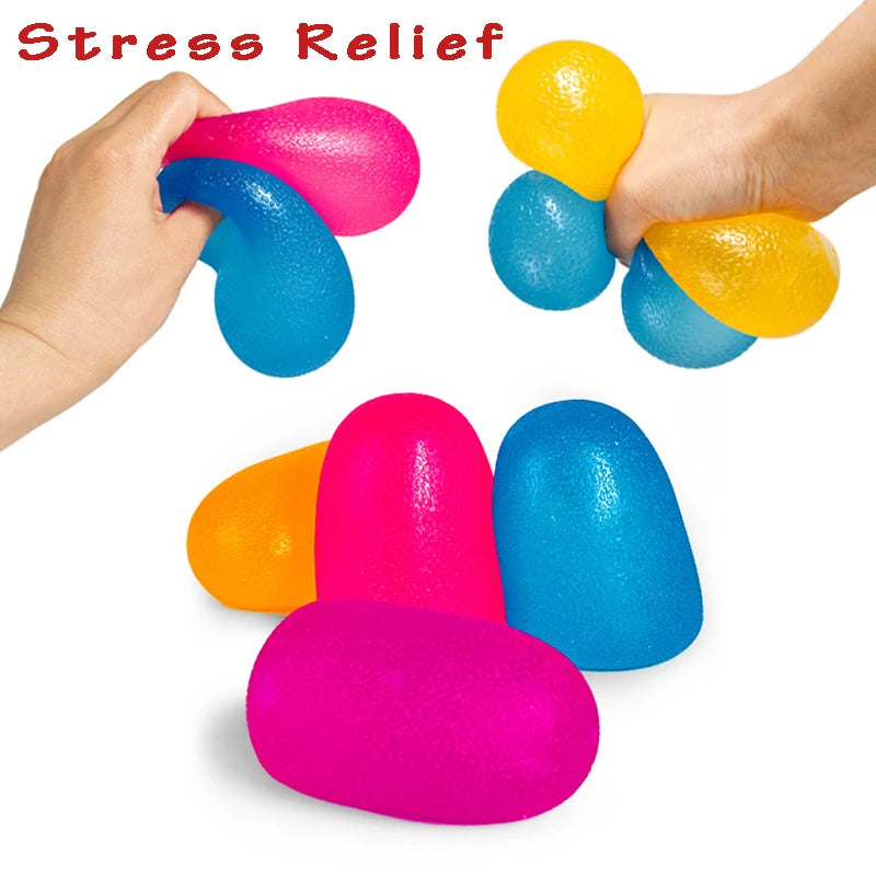 A hand is squeezing a bright pink squishy stress relief ball and a blue one, with other colored balls scattered below.