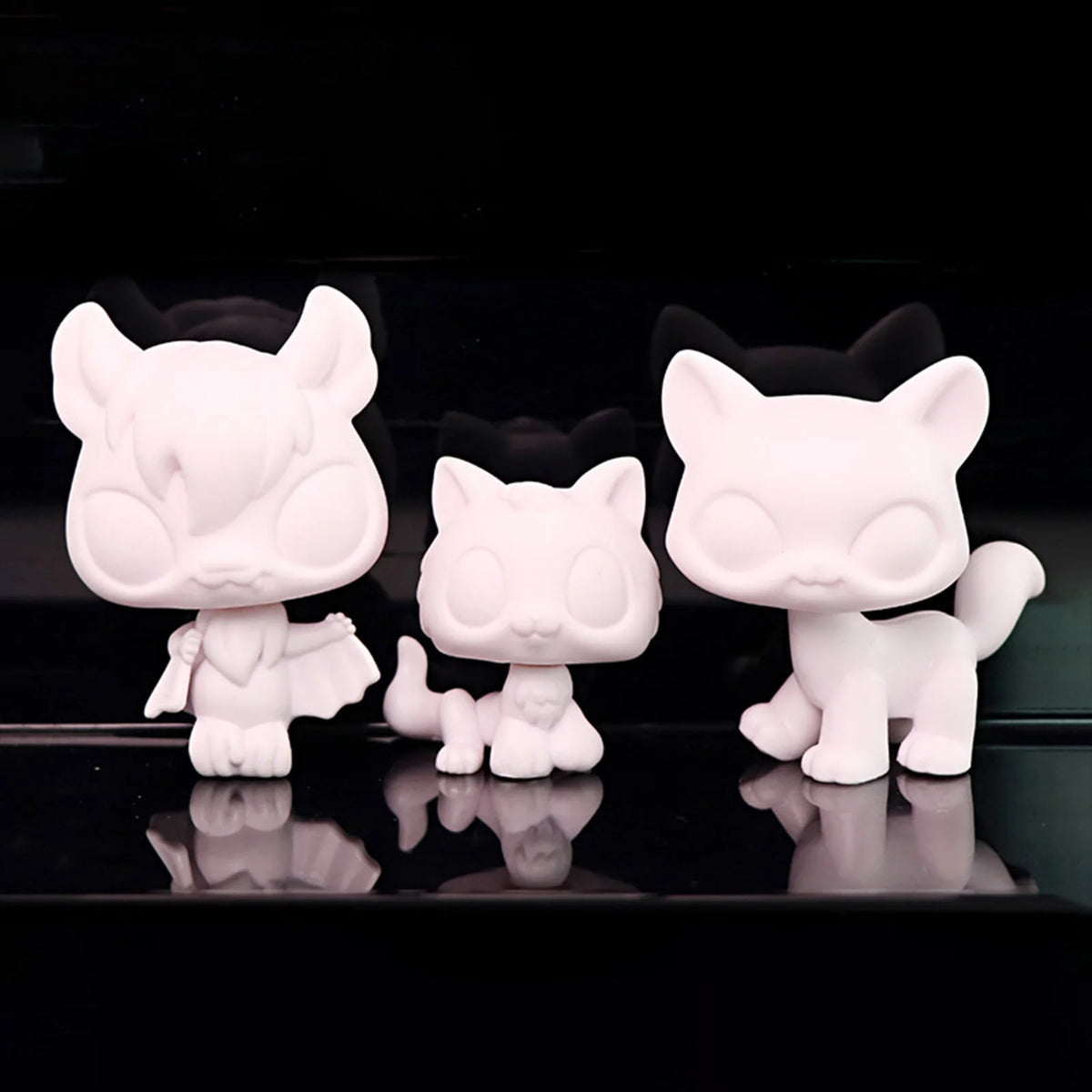 A set of three white printable bobble head figurines are displayed against a black background.