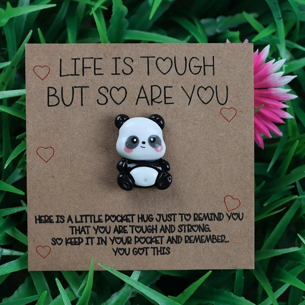 A brown greeting card with a white panda figurine and text that reads Life is tough but so are you