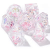 A set of seven pink floral butterfly resin polyhedral dice for tabletop role-playing games