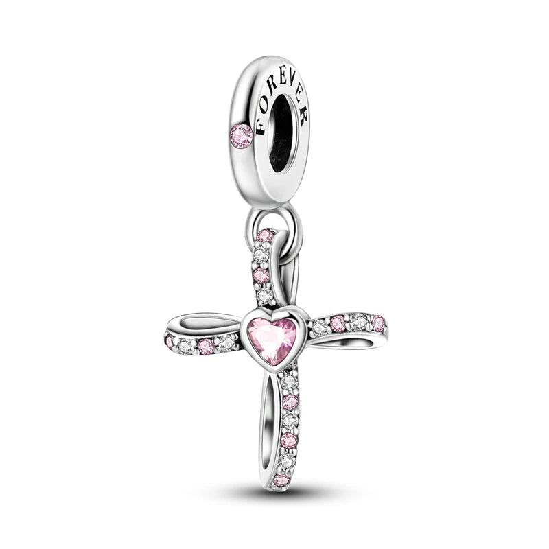A silver heart charm bead with a cross design and pink zircon stones.