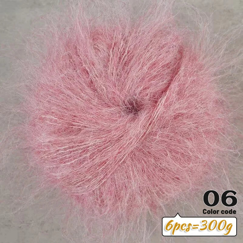 A close-up of pink long-haired alpaca blend yarn in a fluffy ball, labeled as color code 06.